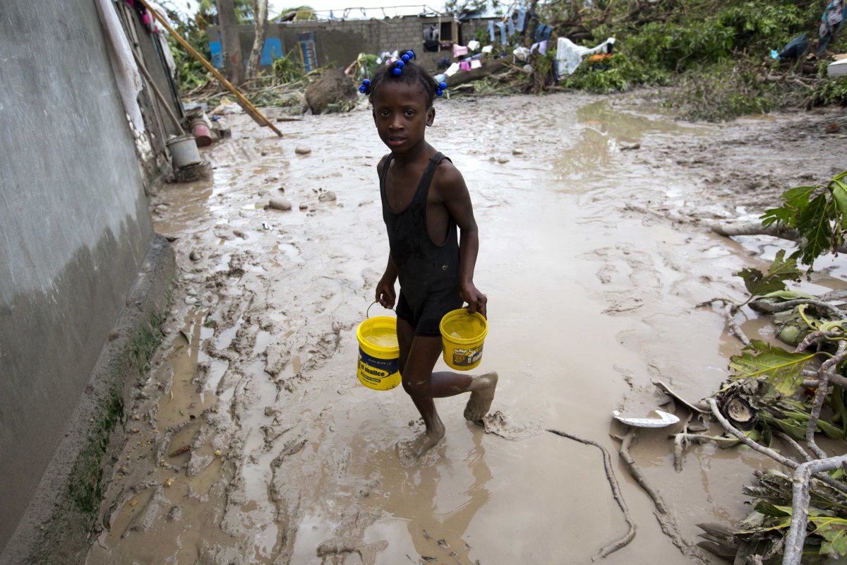 a-girl-lugs-buckets-of-drinking-water-in-the-aftermath-of-hurricane-matthew-in-les-cayes